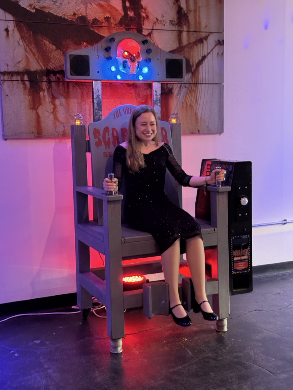 Smiling player in a black dress taking on the electric chair game