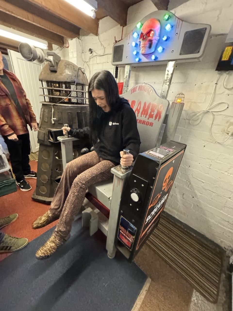 Player holding both metal handles of the Screamer electric chair game