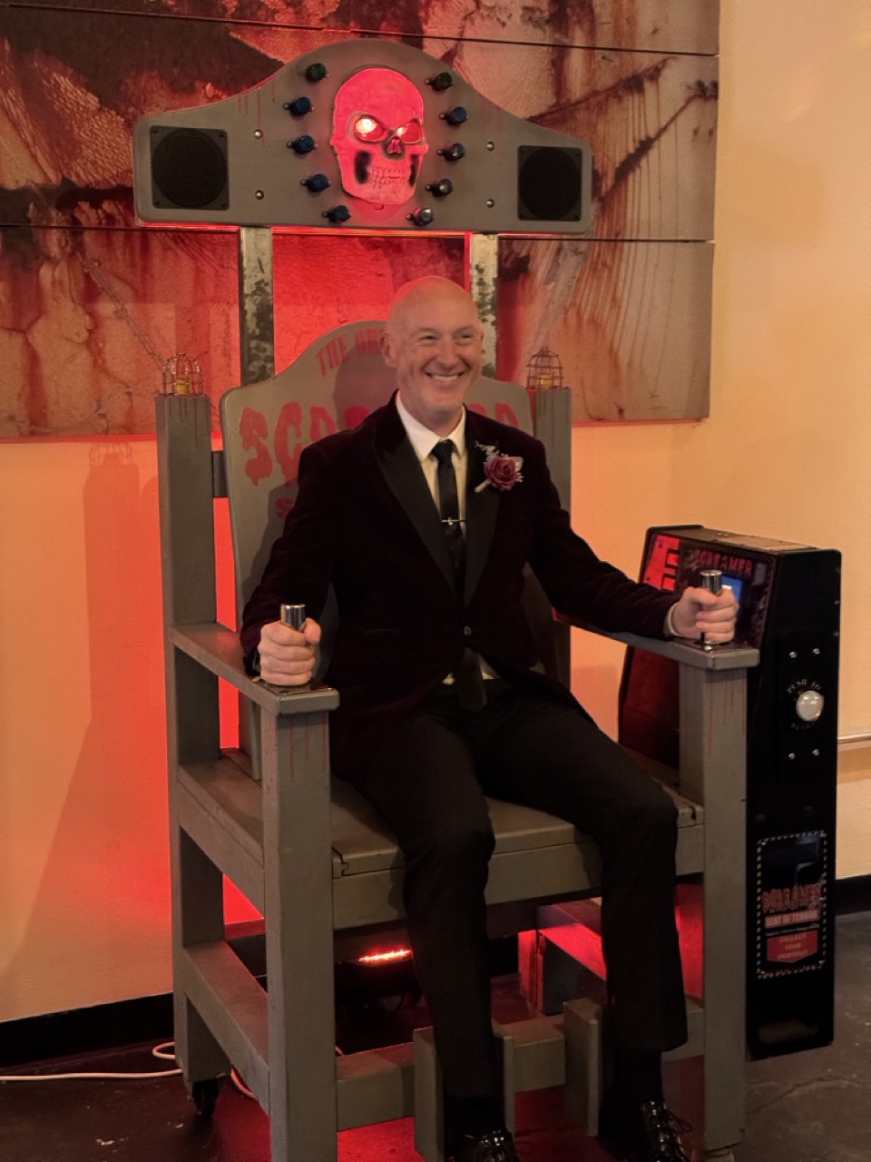 Smiling player in a suit gripping the electric chair game handles
