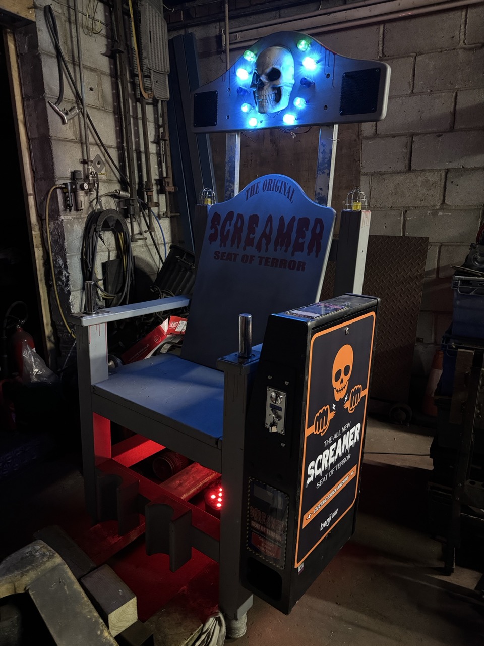 Grey Screamer arcade chair with illuminated skull and coin-operated unit